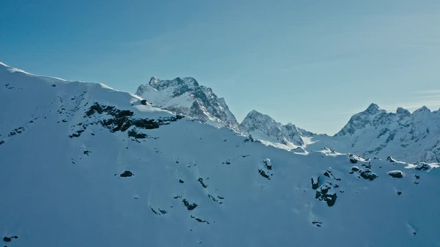 Snow capped mountains on a blue sky in sunny weather, flight, Caucasus mountains