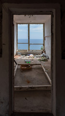 Fototapeta na wymiar A room in a ruined hotel with a sea view