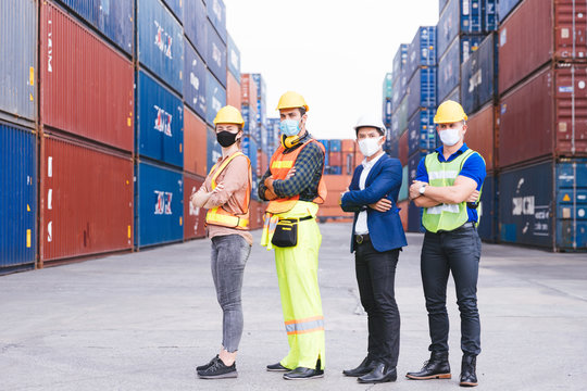 Portrait group of smart creative workers wear protective face masks, safety helmet and uniform for safety in machine industrial factory. Logistic import export and transport industry background.