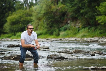 Bearded man catching fish. Summer leisure. Mature man fishing on the pond. Portrait of cheerful senior man fishing. Male fishing. Fishman crocheted spin into the river waiting big fish