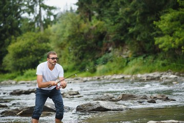 Bearded man catching fish. Summer leisure. Mature man fishing on the pond. Portrait of cheerful senior man fishing. Male fishing. Fishman crocheted spin into the river waiting big fish