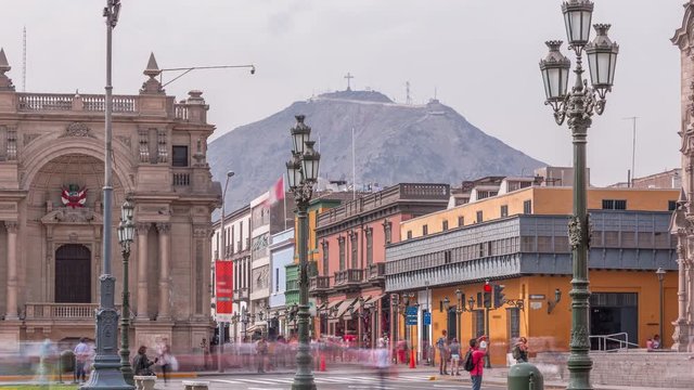 The Plaza de Armas with green lawn and flowers timelapse, also known as the Plaza Mayor, sits at the heart of Lima's historic center. San Cristobal hill on a background