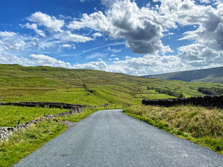 Fototapeta na wymiar On the moor top at Cray, with the road leading down to Kidstones Bank, on a cloudy day near Buckden, Skipton, UK