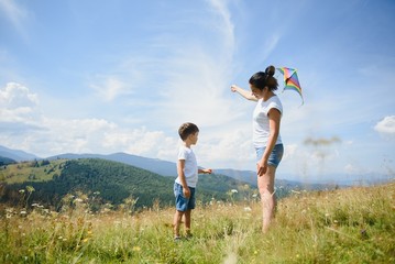 Little boy flies a kite into the blue sky