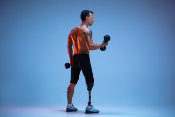 Athlete with disabilities or amputee isolated on blue studio background. Professional male...