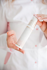 Cosmetic bottle in the hands of a beautician