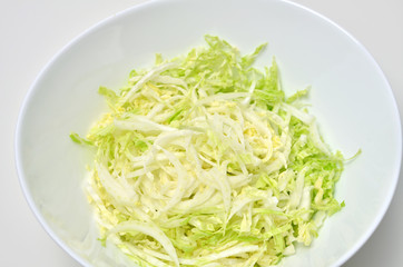Napa cabbage salad in bowl on white background. Vegan food.