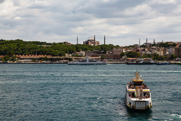 Naklejka premium Panoramic shot of the old town Istanbul; The Hagia Sophia (Ayasofya) Mosque Eminonu, ferries and boats on the Golden Horn, Istanbul, Turkey.