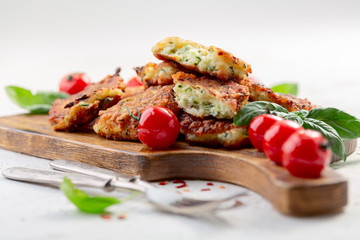 Zucchini pancakes or fritters with caramelized tomatoes.