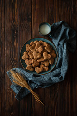 Top view on homemade wholegrain cookies with oatmeal, raisin, nuts, seeds and milk on brown rustic wooden background. Healthy eating concept.  Copy space