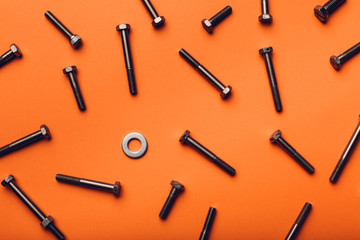 Bolts and nuts closeup on orange background.