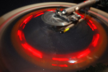 The Perseid meteor shower can be seen in the starry sky. In the foreground is a red circle of light