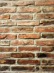 Part of an old red brick wall with cement. Close-up old brick wall texture. Wall of red stones. Masonry with cement. Macro shot of wall.