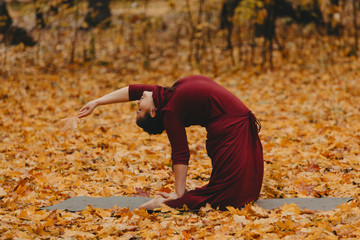 Curvy girl doing yoga in nature.