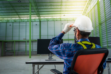 Engineers or contractors work at a desk in a warehouse. Designing a structural building on a computer at a construction site.