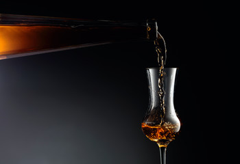 Aged golden fortified wine from the antique bottle being poured into a crystal glass.