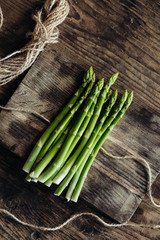 Bunch of fresh green asparagus on wood board. Close up