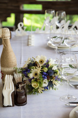 Banquet table setting with white plates, glass glasses.