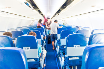 Empty plane interior with few people and stewardess during coronavirus pandemia