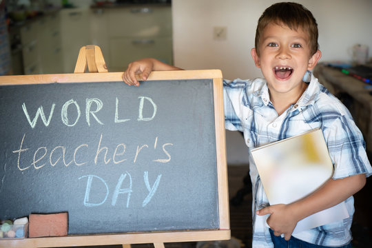 World Teacher's Day greeting, pupil boy near the chalkboard, chalk inscription text - Powered by Adobe