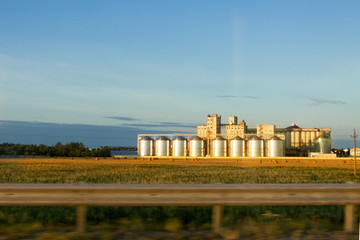 Silos grain store middle field blue sky background autumn fall sunset © svetlana