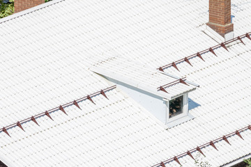 White modern flat roof from texture corrugated metal with dormer window and smokestack