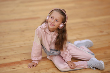Naklejka premium Cheerful child in headphones. Autumn spring concept. street portrait of a girl. Child in the park