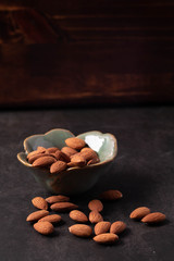 Almonds in ceramic cups on a black background