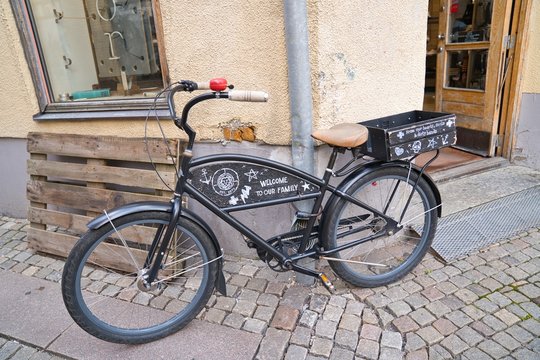 Cute black bicycle parked on the street corner