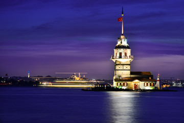 Fototapeta premium Maiden's Tower or Kiz Kulesi at night with motion blur boats - Istanbul, Turkey.