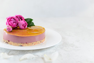 Mousse cashew cake with orange and cherry, decorated with roses and peonies. Sugar, lactose, gluten free. Horizontal orientation, copy space.