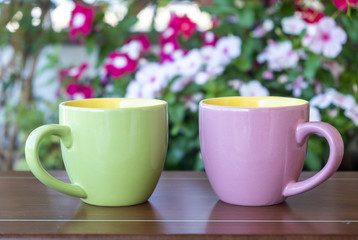 Coffee cup mockup on a table, blur green background.