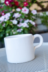 Coffee cup mockup on a table, blur green background.