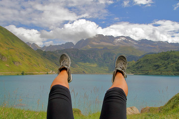 Gambe di donna con montagne e lago 