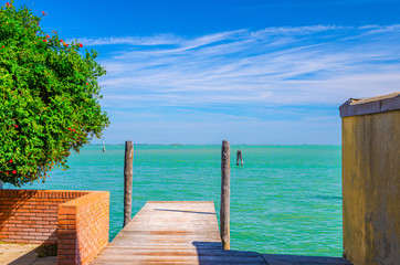 Wooden pier in turquoise water of Venetian Lagoon