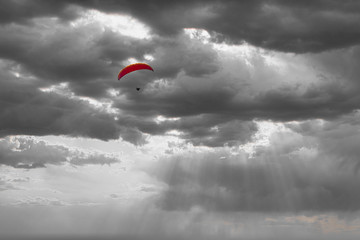Dramatic image of a paraglider under a cloudy sky