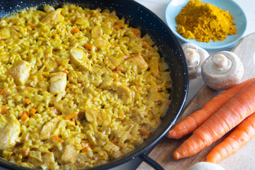Chicken curry paella in a traditional spanish pan.