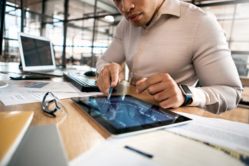 Businessman analyzing stat and dynamic on forex charts at tablet computer
