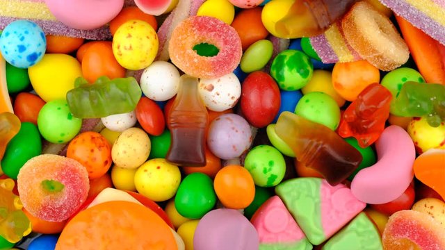 Candy sweets background. Assorted colorful mixed candies. Colorful delicious sweets turning top view.