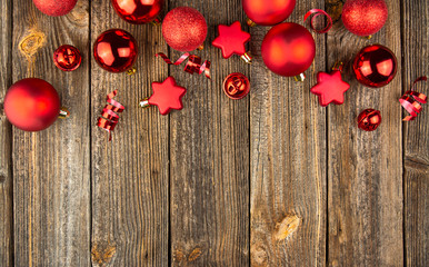 Fototapeta na wymiar Christmas background with red toys and decorations on a wooden table. Christmas card. Baner. Flat layer. Top view with copy space.