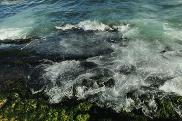 blue ocean with big rocks and waves.