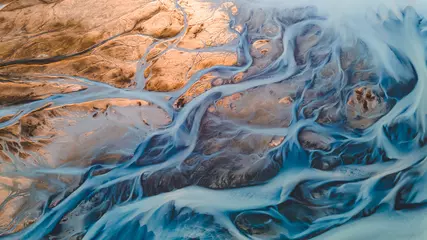 Fototapeten Gletscherflüsse von oben. Luftaufnahme der Flussströme von isländischen Gletschern. Wunderschöne Kunst der Mutter Natur, geschaffen in Island. Hintergrundbild Hintergrund Foto in hoher Qualität © Marek