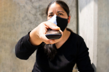 Woman watches television while wearing a mask