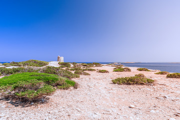 Fototapeta na wymiar Beautiful view of the old observation tower (Torre De Ses Portes) and coast of the Ibiza island.