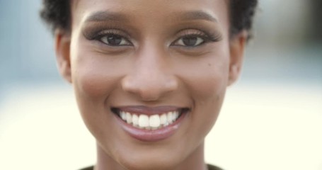 Close up blurred indistinct out unfocused portrait of African American young friendly confident woman with short hair, millennial female dark skin face with wide wrinkled white teeth looking at camera