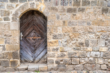 Sehr alte Holztür in einer historischen Stadtmauer als Hintergrund oder Textur mit Textfreiraum
