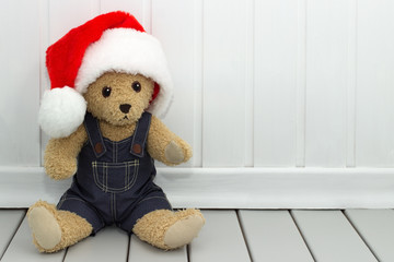 Baby stuffed toy teddy bear in a red santa hat.