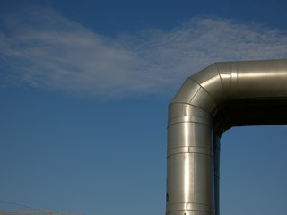 Heating pipeline under blue sky - hot water metal pipe knee in a residential area, Gdansk, Poland 
