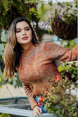Beautiful model posing for photos on the street. Wearing jeans and brown blouse. 
