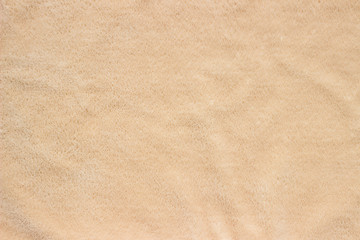 Fototapeta na wymiar Faux fur texture of cream color for background. Soft and delicate plush fabric with pile of beige color.